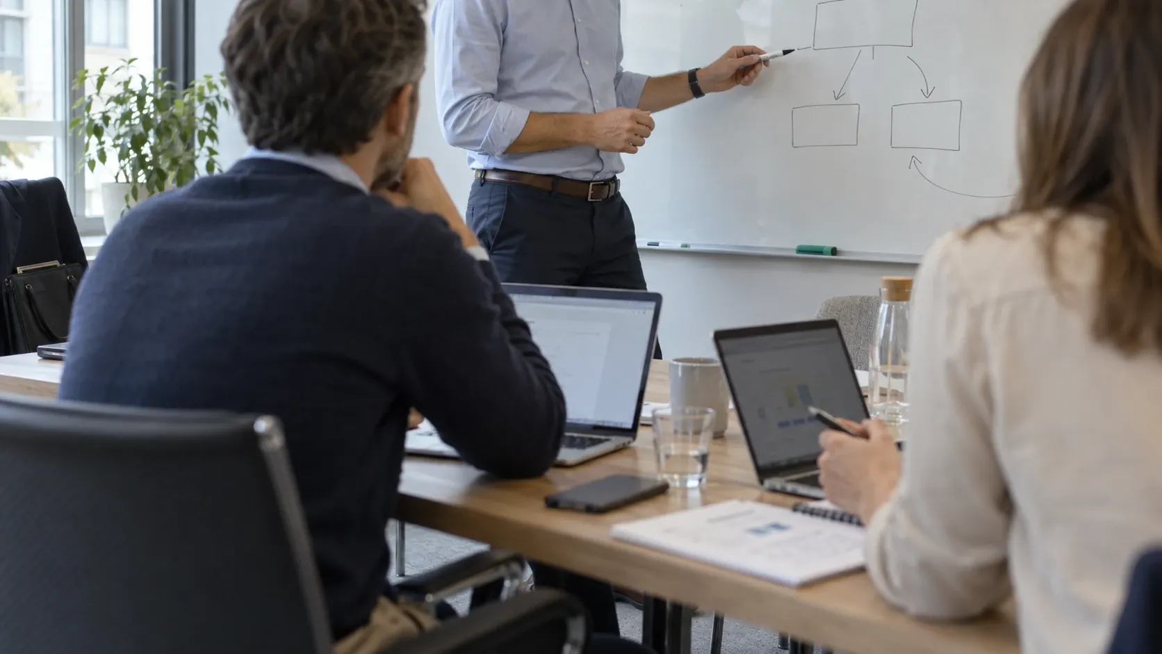 A consultant explaining a process at a whiteboard
